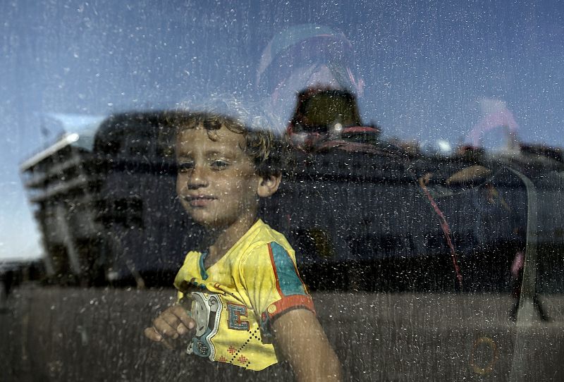 Un niño sirio observa a través del autobús el buque "Eleftheros Venizelos"