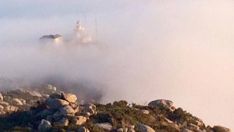 El Faro de Finisterre asoma entre la densa capa de nubes y anuncia el final del camino