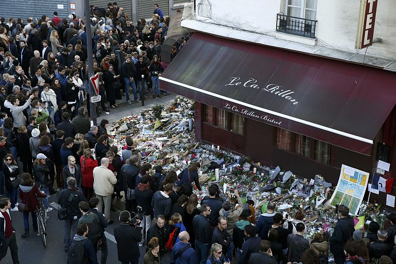 Una multitud de personas rinde homenaje enfrente del restaurante Le Carrillon, uno de los que sufrió los atentados