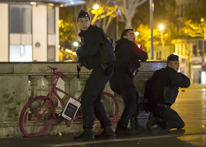 LAN154. Paris (France), 15/11/2015.- Armed French police officers take up positions on Place de la Republique after an allegedly false alert sparked mass panic amongst the gathered crowd in Paris, France, 15 November 2015. More than 129 people have b