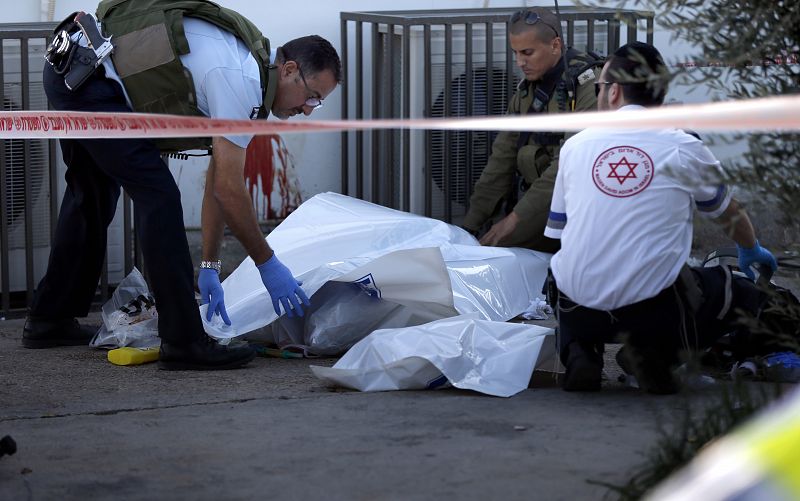 Los servicios de emergencia retiran el cadáver de un israelí apuñalado por un palestino en una gasolinera de Cisjordania, el 23 de noviembre de 2015.