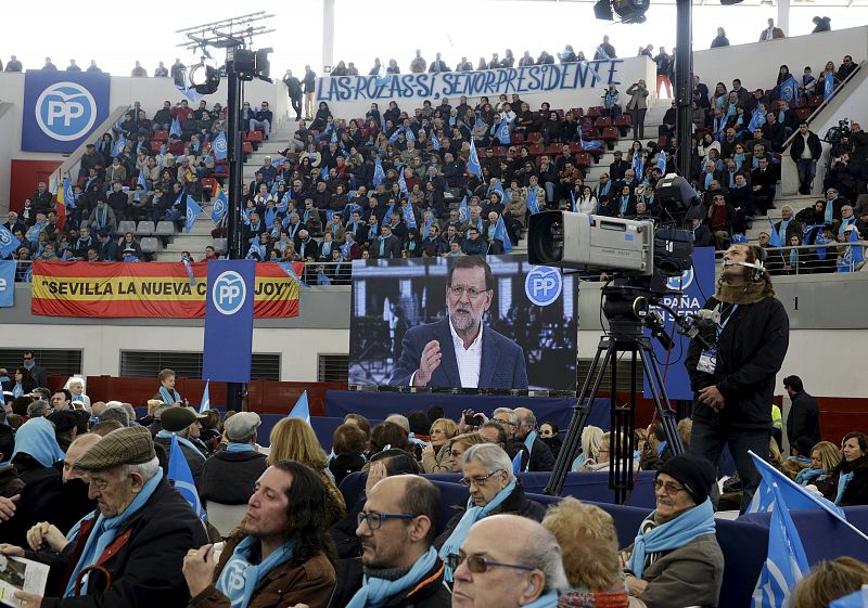 Spanish Prime Minister Mariano Rajoy, one of the four leading candidates for Spain's national election is seen on a screen during a campaign rally in Las Rozas