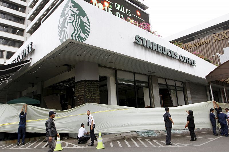 Varios operarios despliegan en cordón ante la cafetería Starbucks que ha sido objeto de los ataques