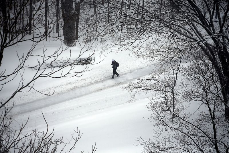 Un hombre camina por una calle cubierta de nieve