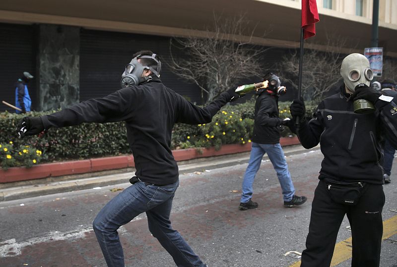 Un manifestante lanza una bomba de gasolina a la policía