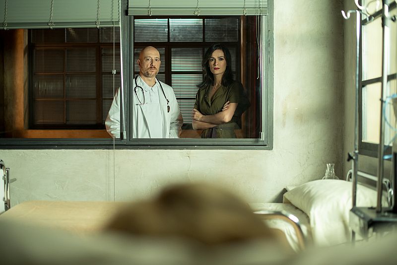 El doctor Vargas y Susana Torres observan a Irene en la enfermería del Ministerio