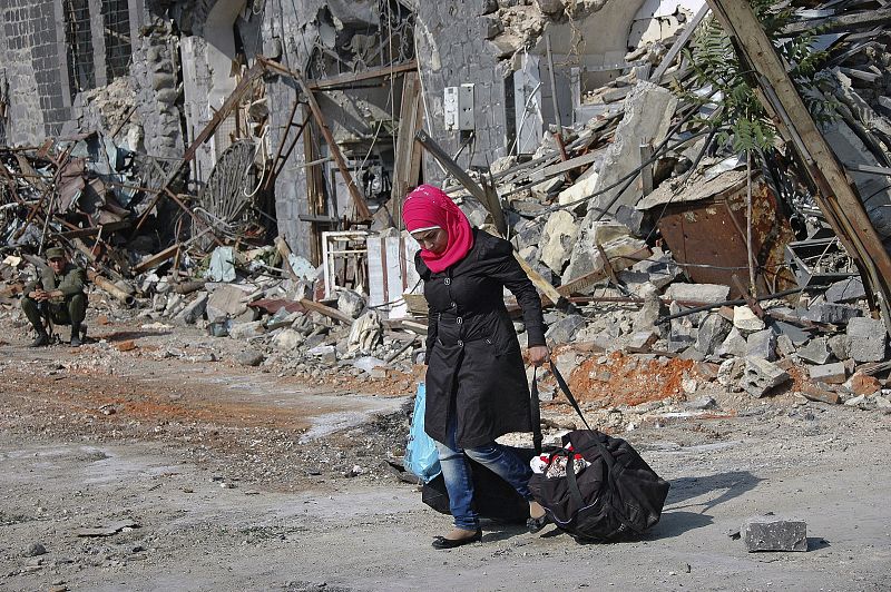 Una mujer arrastra sus pertenencias en el casco antiguo de la ciudad de Homs, asediada durante más de 20 meses, en mayo de 2014.