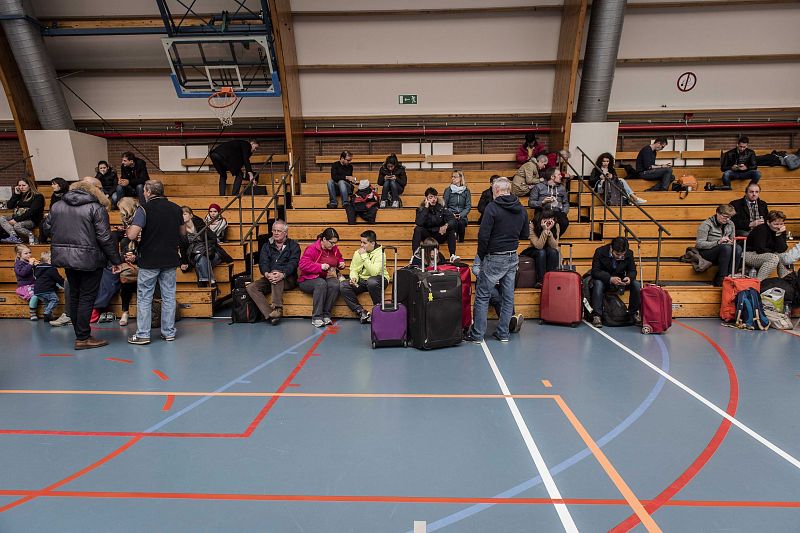 Varios pasajeros descansan en un polideportivo en Zaventem, cerca de Bruselas (Bélgica)
