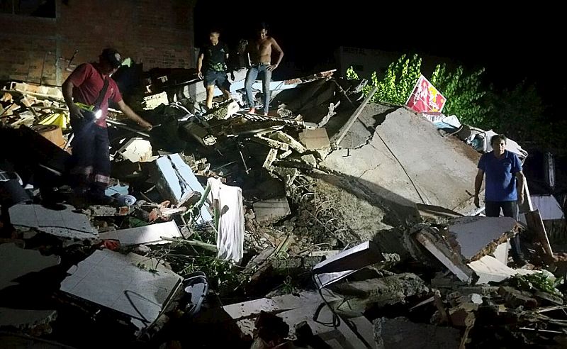 Varias personas sobre los escombros de un inmueble afectado por el terremoto en Manta