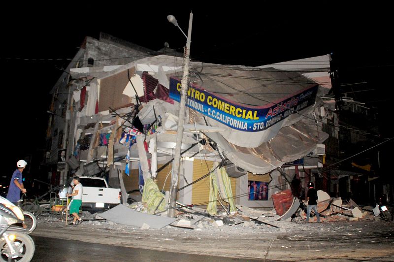 Varias personas junto a uno de los edificios dañados en Manta, en la costa del Pacífico
