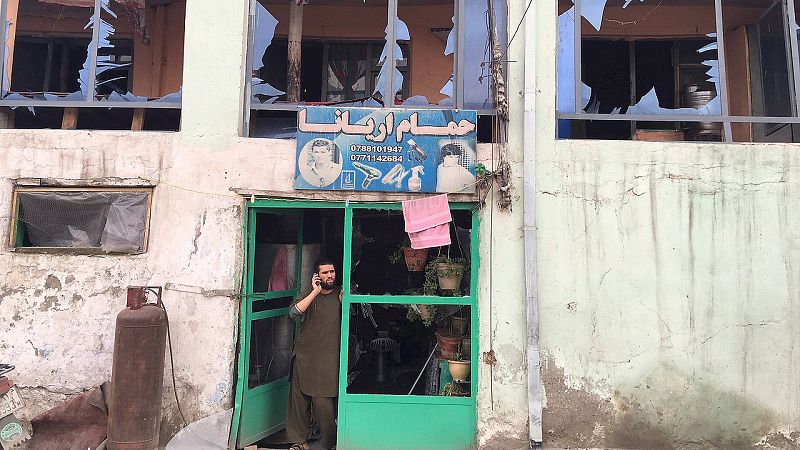 Un hombre habla por su teléfono móvil desde la entrada a su tienda dañada por el atentado. Los talibanes afganos han reivindicado la acción como parte de su "ofensiva de primavera". EFE/Jawad Jalali