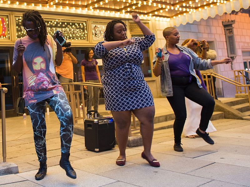 La gente baila durante una vigilia con velas en memoria de Prince a las afueras del Teatro Warner en Washington