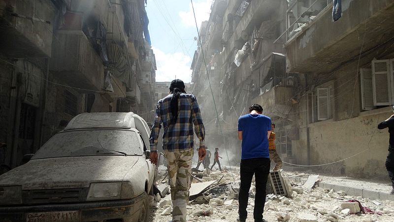 Varias personas en una calle de Alepo destruida por los bombardeos
