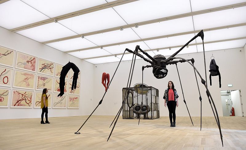Una empleada del museo posa para los fotógrafos junto a trabajos de la artista Louise Bourgeois en las nuevas instalaciones del museo Tate Modern en Londres.