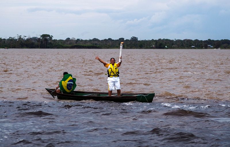 La antorcha, a bordo de una canoa y portada por Raimunda Freitas, en la confluencia de los ríos Negro y Solimoes.