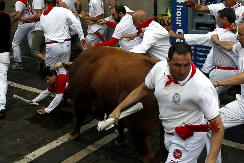 Un toro embiste a un mozo durante el segundo encierro