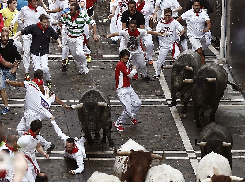 Varios toros de la ganadería de José Escolar Gil salen de la curva de Mercaderes durante el tercer encierro de San Fermín 2016