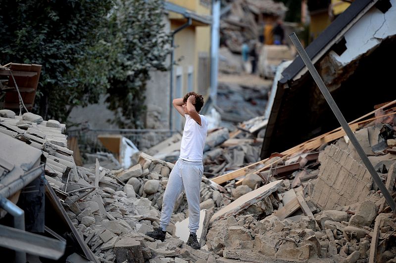 Un hombre se muestra abatido en medio de los edificios caídos en Amatrice