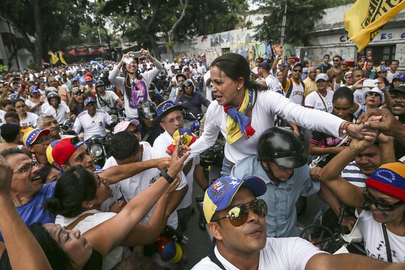 La dirigente opositora Maria Corina Machado saluda a manifestantes