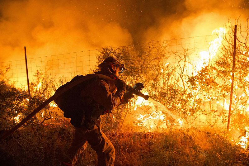 Bomberos intentan controlar las llamas en las montañas de Santa Cruz, en California. El incendio forestal ha quemado ya más de 200 hectáreas y el humo es visible desde la bahía sur de Los Ángeles.
