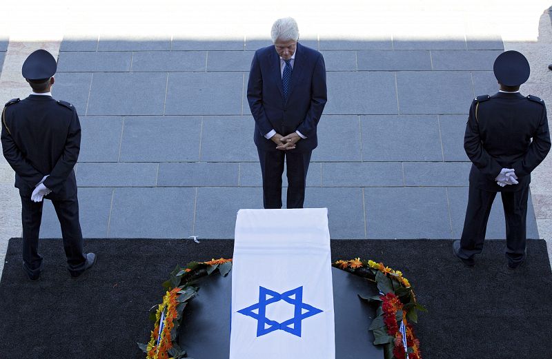 El expresidente estadounidense Bill Clinton (c) presenta sus respetos ante el féretro del expresidente israelí Simón Peres