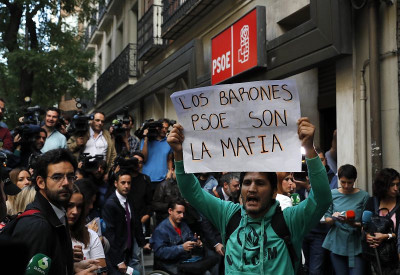 Un simpatizante muestra una pancarta a las puertas de la sede del PSOE
