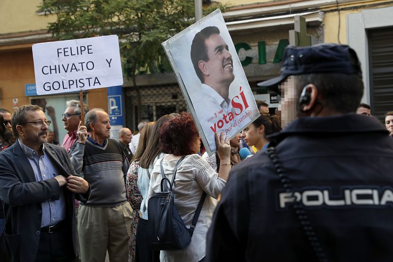 Dos simpatizantes muestran sendas pancartas a las puertas de la sede del PSOE