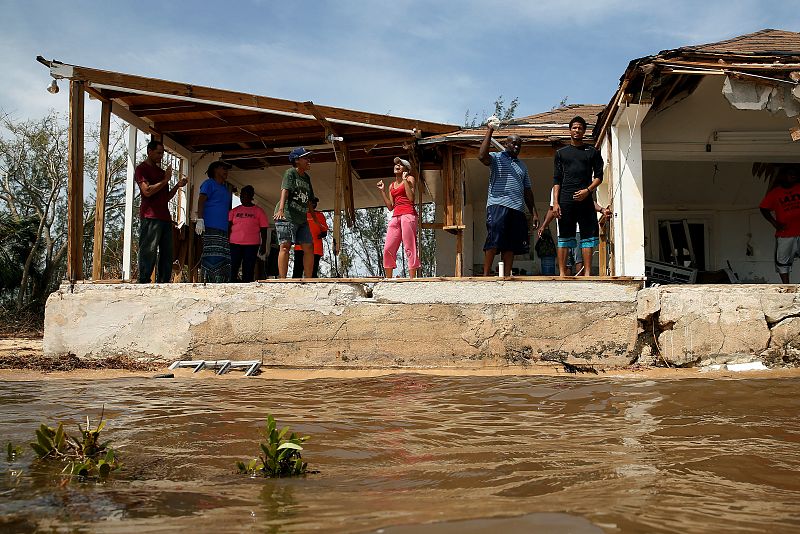 Miembros de la United Fellowship Ministries International Church realizan una servicio religioso improvisado sobre las ruinas de su iglesia destruida por el huracán Matthew en South Beach, Bahamas