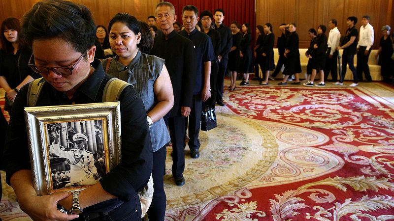 Una mujer sostiene una foto del fallecido rey de Tailandia, Bhumibol Adulyadej, en la cola para ofrecer sus condolencias en el Gran Palacio de Bangkok, el 14 de octubre de 2016. REUTERS/Athit Perawongmetha