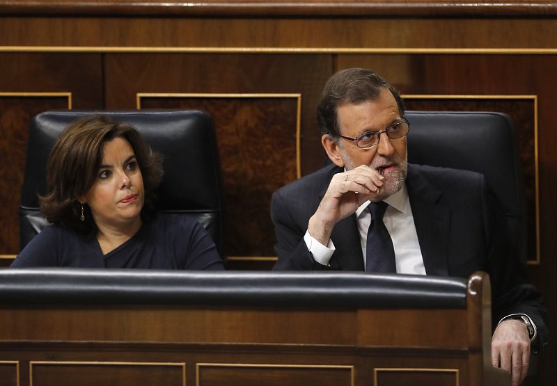 El presidente del Gobierno en funciones, Mariano Rajoy, acompañado por la vicepresidenta, Soraya Sáenz de Santamaría, escucha la intervención del portavoz del PSOE, Antonio Hernando.