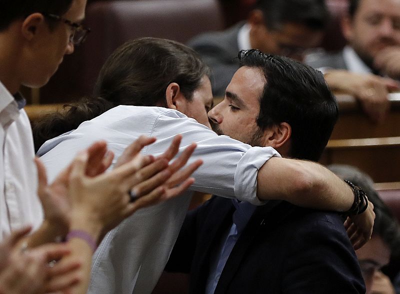 El secretario general de Podemos Pablo Iglesias (2i), saluda al líder de IU, Alberto Garzón (d), tras su intervención.