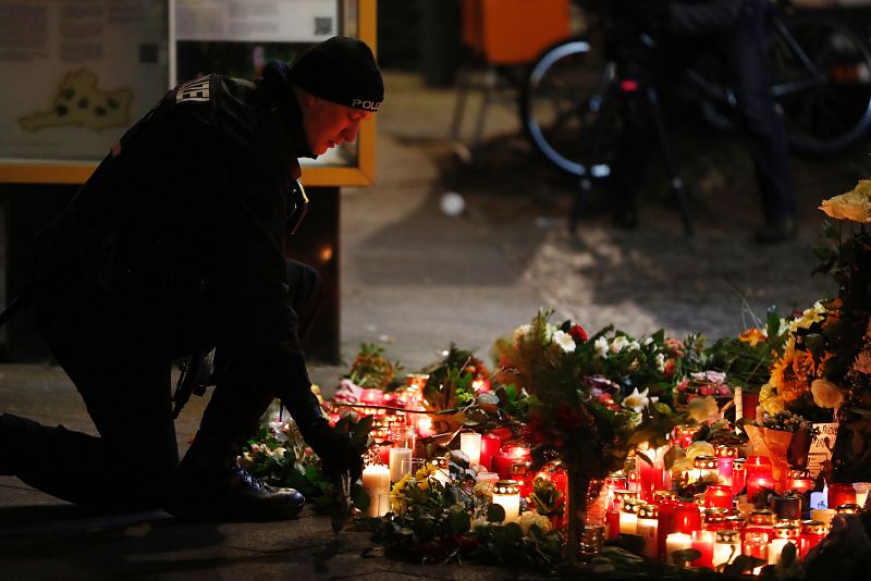 Un policía deja flores en la plaza de la Gedächtniskirche, iglesia emblemática de Berlín occidental bombardeada durante la Segunda Guerra Mundial.