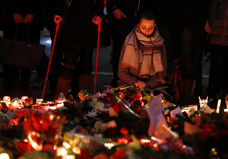 Una mujer rinde homenaje a las víctimas del atentado en un popular mercado navideño en Berlín.