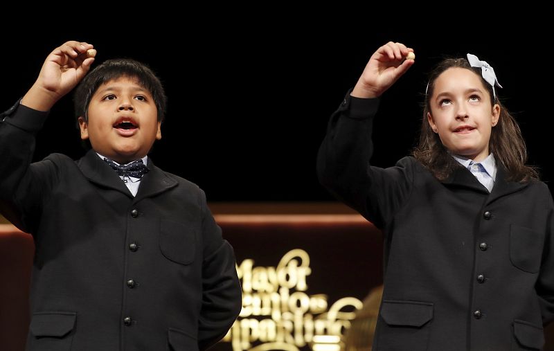 Los niños de San Ildefonso Nerea y Daniel muestran las bolas con el primer cuarto premio que ha recaido en el número 59.444 del Sorteo Extraordinario de Navidad