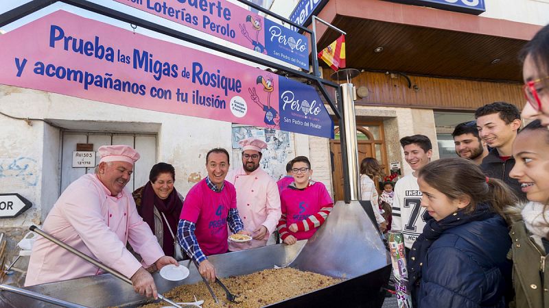 El propietario de "El Perolo" de San Pedro del Pinatar, Murcia, comparte en plena calle con vecinos y agraciados una gran sartén de migas para 600 personas, jamón y productos de la tierra.