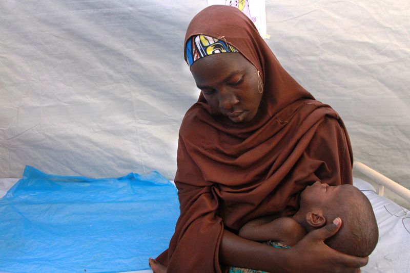 Una madre,que llegó huyendo del conflicto que padece el estado de Borno, espera con su bebé en el hospital de MSF en Pulka. Las patologías más frecuentes entre los pacientes son infecciones respiratorias y diarreas acuosas agudas, malaria, gastritis