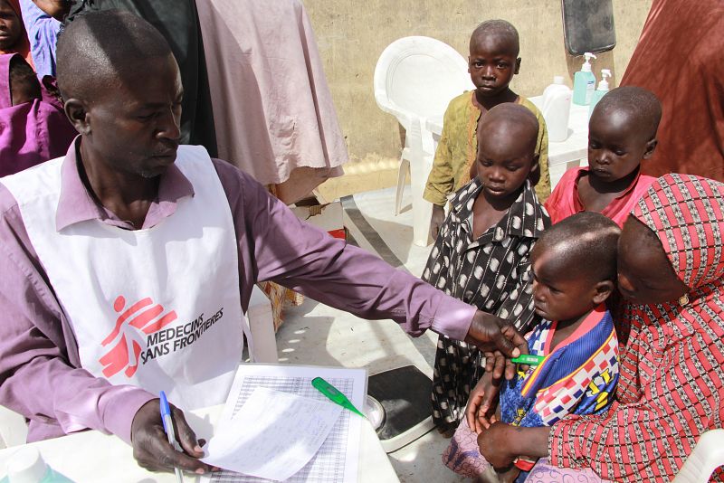 Un trabajador humanitario de MSF comprueba el estado de salud de un niño. La mayoría de los niños que llegan a Pulka nunca han sido vacunados.