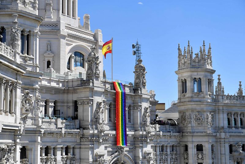 Una bandera arcoiris gigante cuelga de un balcón del Palacio de Cibeles, sede del Ayuntamiento de Madrid