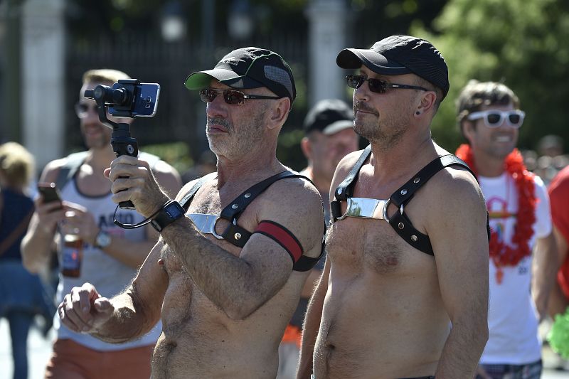 Dos hombres grabando imágenes con su teléfono móvil de la marcha del 'Orgullo' en Madrid