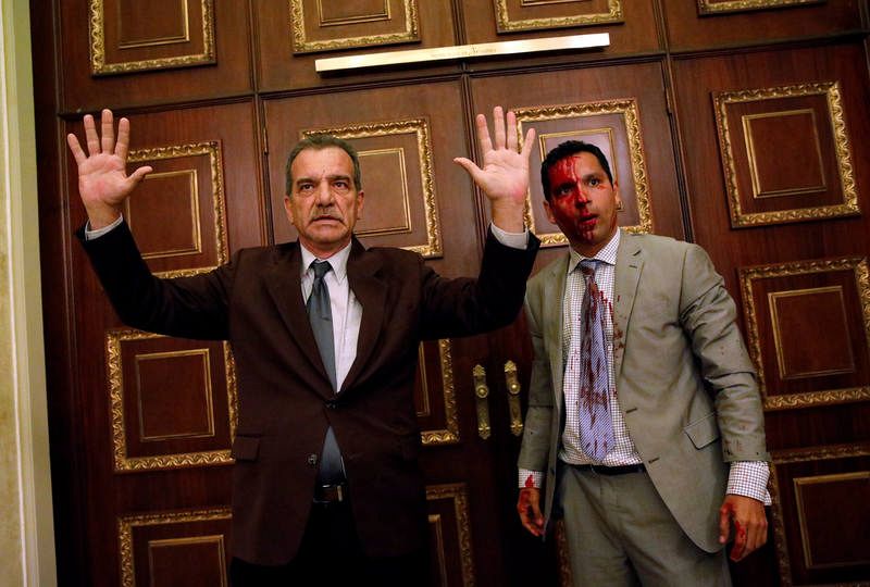 Los diputados de la oposición Luis Stefanelli, a la izquierda con los brazos en alto, y Leonardo Regnault, ensangrentado, durante el asalto a la Asamblea Nacional.