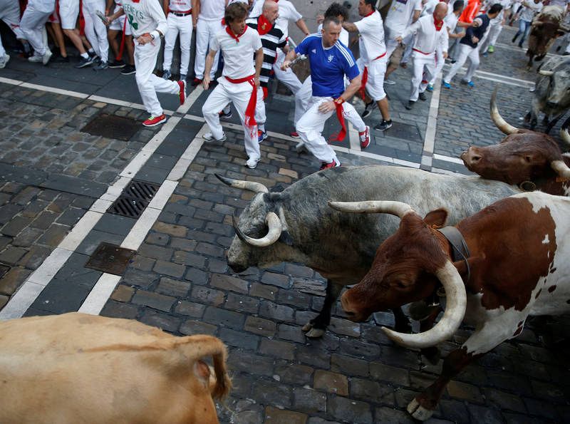Runners sprint ahead of bulls during the first running of the bulls at the San Fermin festival in Pamplona