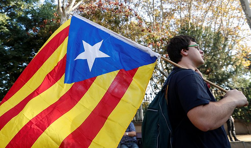 A demonstrator carries a Catalan separatist flag  outside the Catalan regional parliament in Barcelona