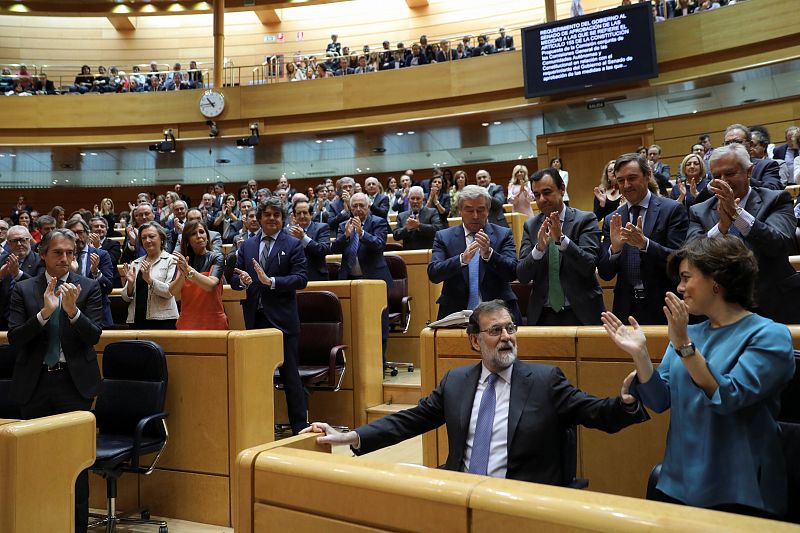 Spain's PM Rajoy is applauded by his fellow People's Party (PP) members after delivering his speech during a debate at the upper house Senate in Madrid