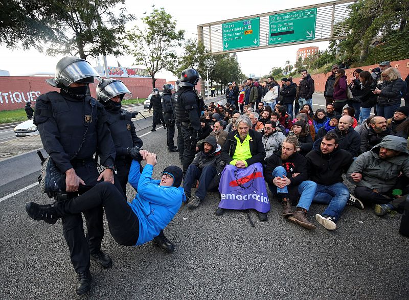 Police remove protestors blocking a ring road in Barcelona during a partial regional strike in Barcelona