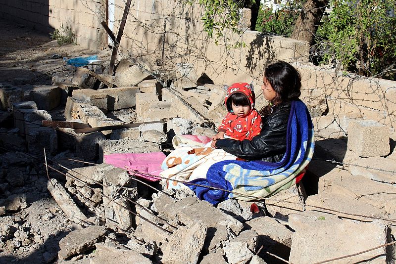 Una mujer permanece junto a su hija y al lado de los restos de un edificio dañado tras el terremoto en la ciudad iraquí de Darbandiján