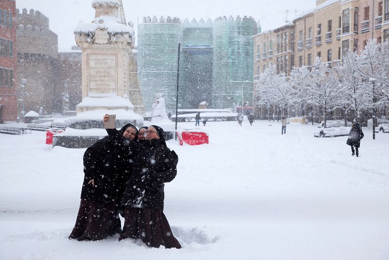 Tres monjas se hacen un selfi en el Mercado Grande de Ávila durante la nevada que cubre la ciudad