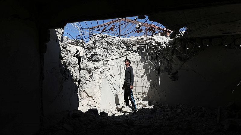 Man inspects a damaged house in Bosra al-Sham town, near Deraa