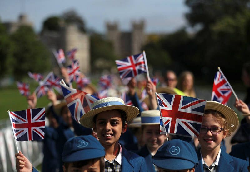 School children wave flags on the Long Walk a day before Prince Harry and Meghan Markle's wedding at Windsor Castle, Windsor