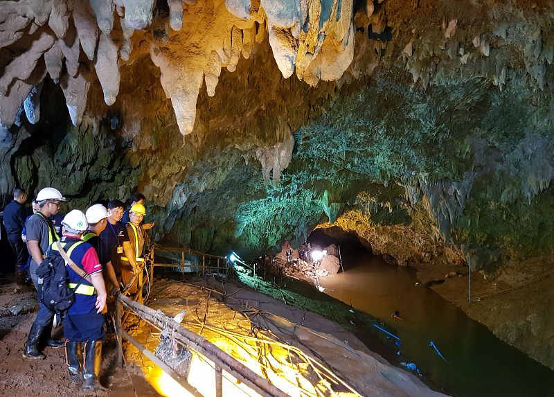 Varios miembros de los servicios de rescate tailandeses mientras inspeccionan la cueva
