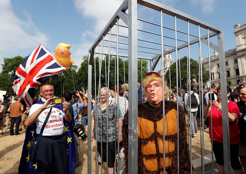 Un manifestante disfrazo de gorila encarcelado con una careta de Trump